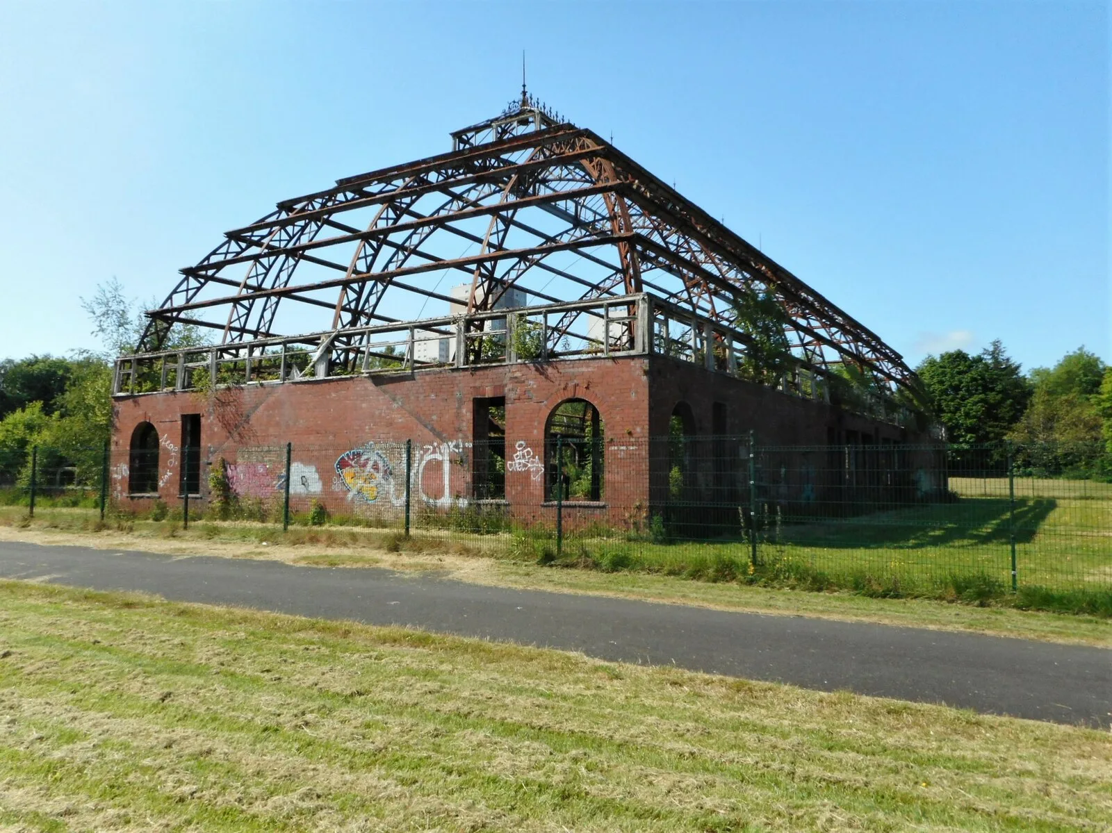 The roofless rusting iron frame of the derelict Springburn Winter Gardens glasshouse in Springburn Park