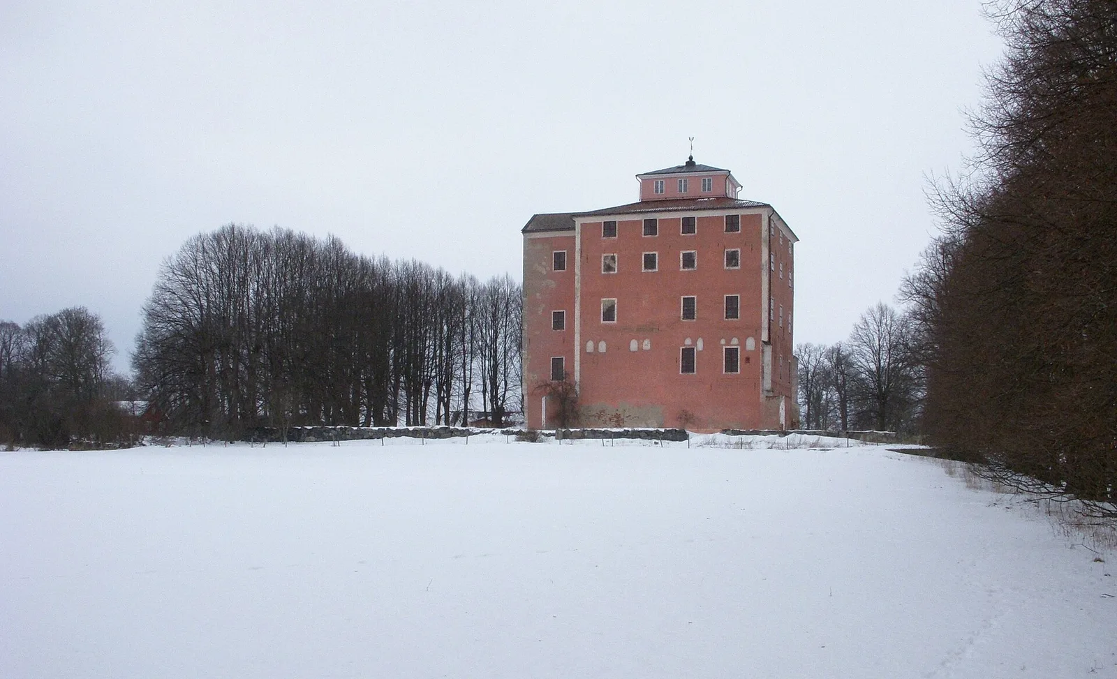 The derelict Tynnelsö castle, a red manor-castle on an island in Lake Mälaren in winter