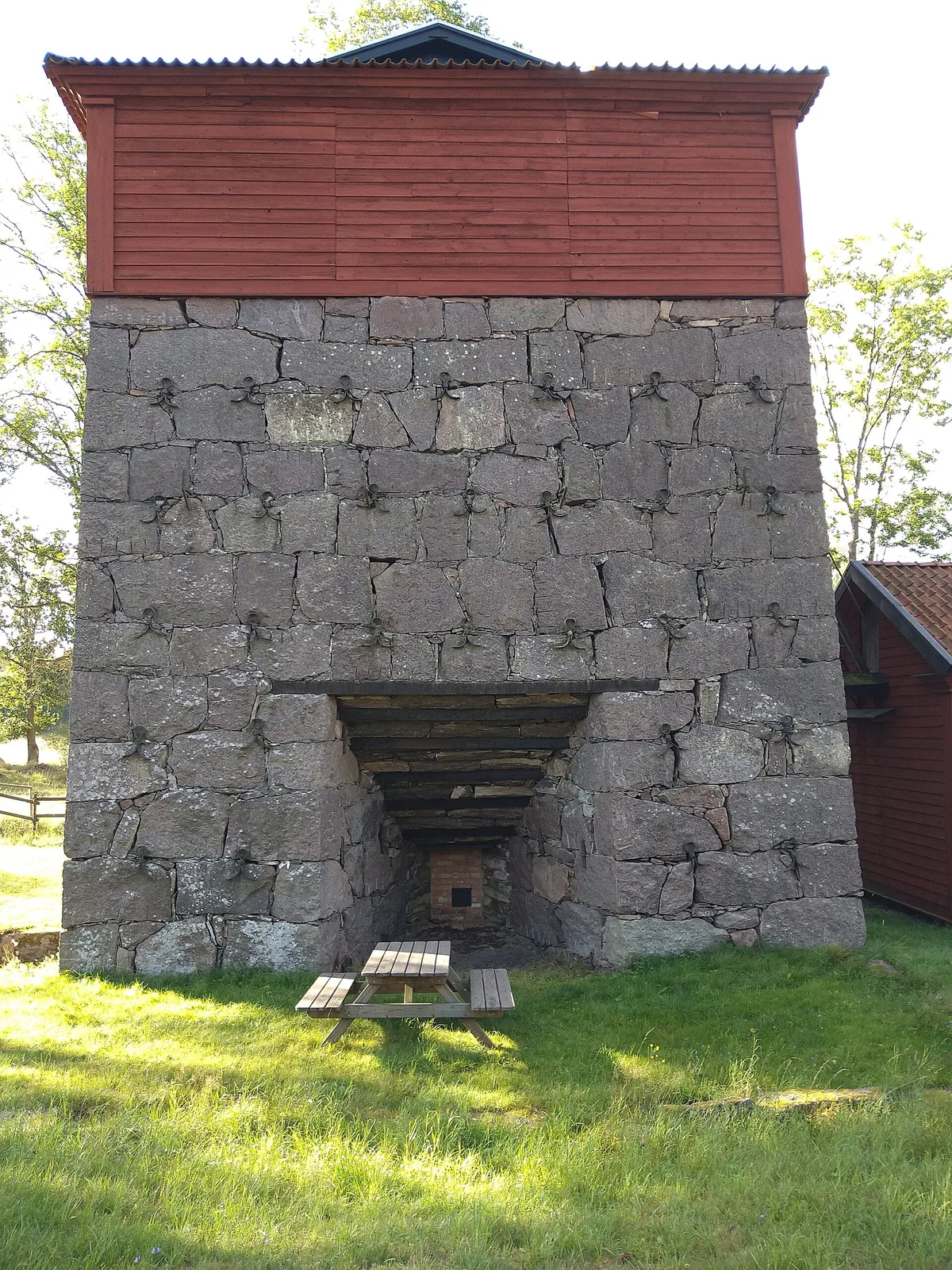 The preserved Hagelsrum blast furnace, a stone base with a red wooden top, in Småland