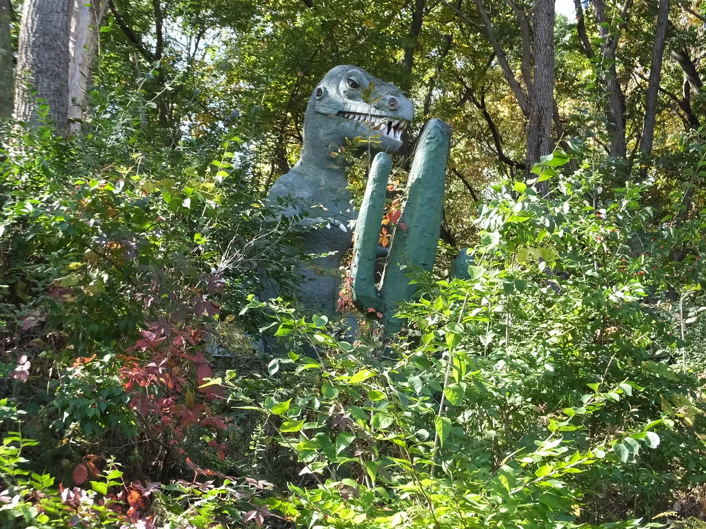 Dinosaure en fibre de verre couvert de lichen au parc abandonné Prehistoric Forest dans le Michigan