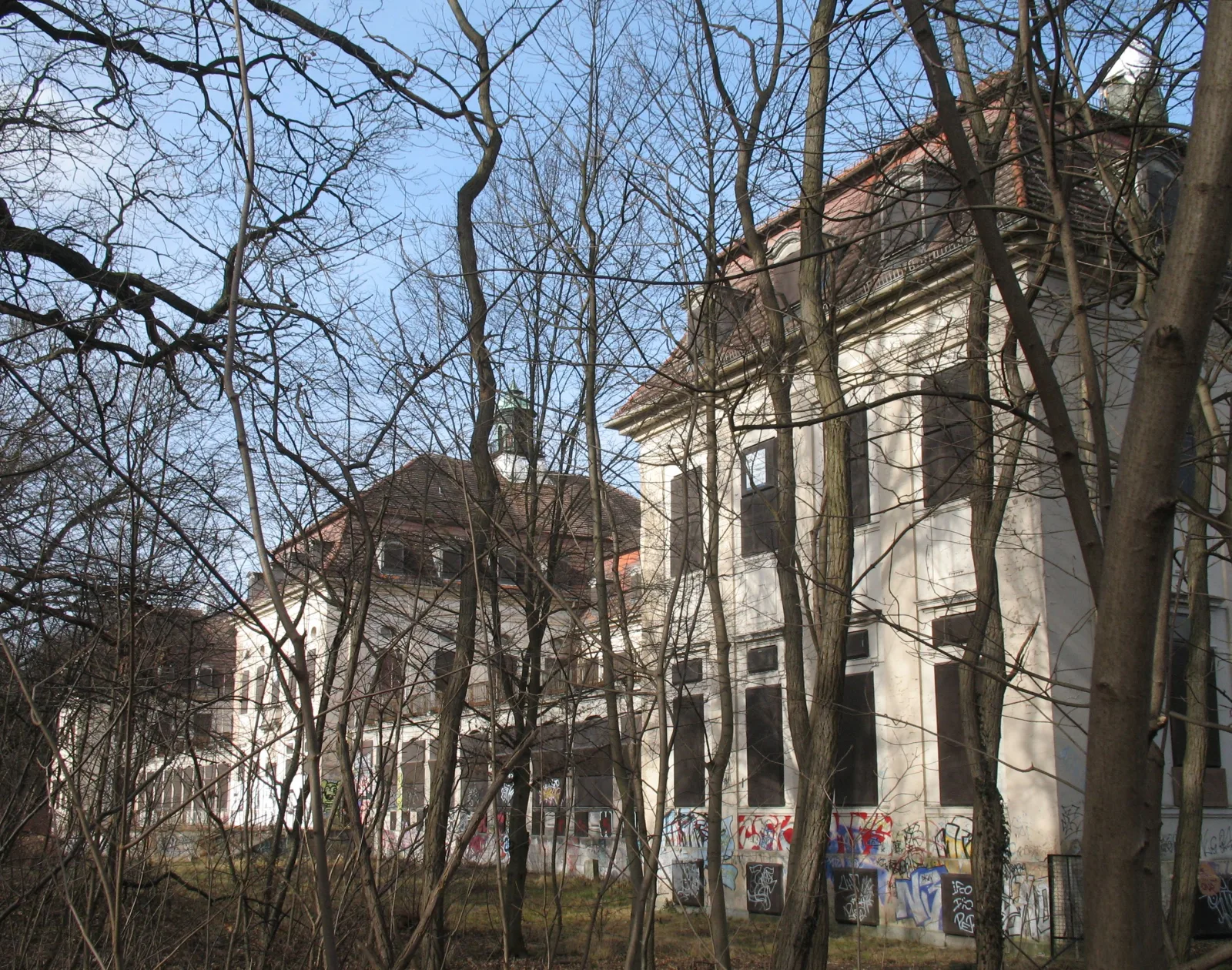 Das verlassene ehemalige Waldsanatorium Waldhaus in Berlin-Buch, zwischen Baeumen versteckt