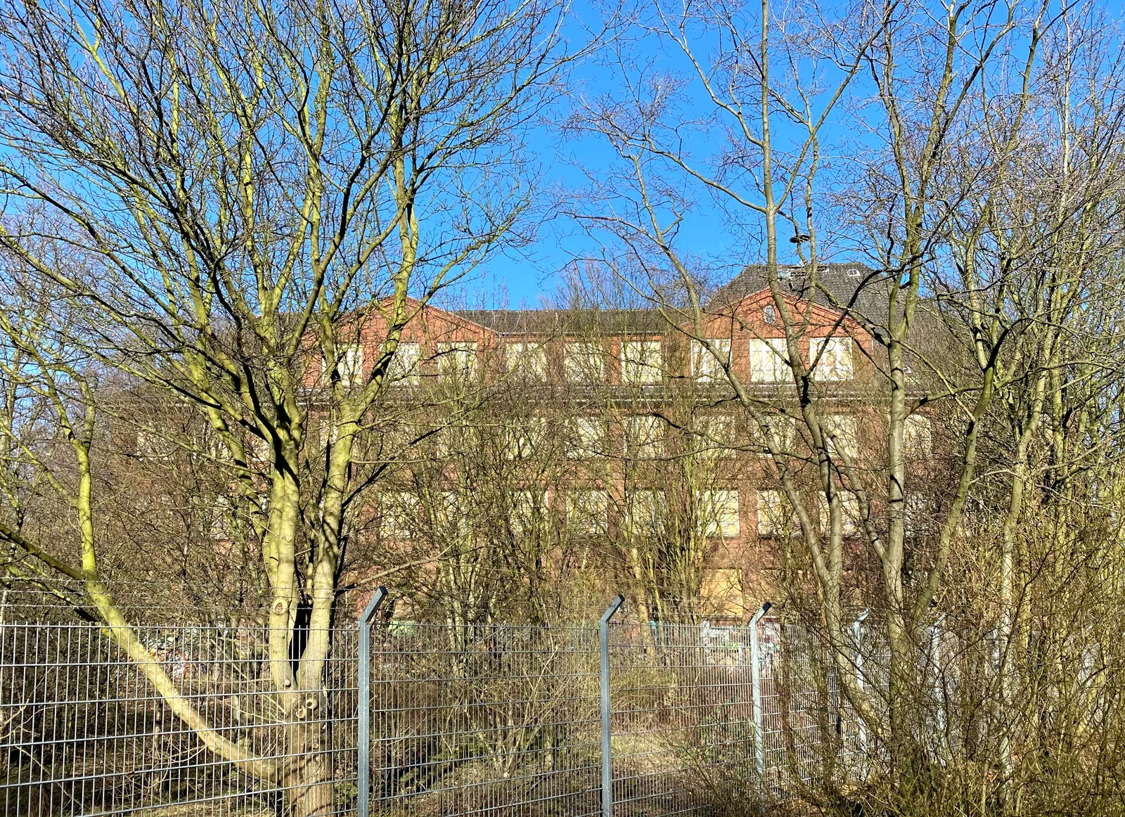 Die leerstehende Backsteinschule am Neuhöfer Damm in Hamburg-Wilhelmsburg mit vernagelten Fenstern