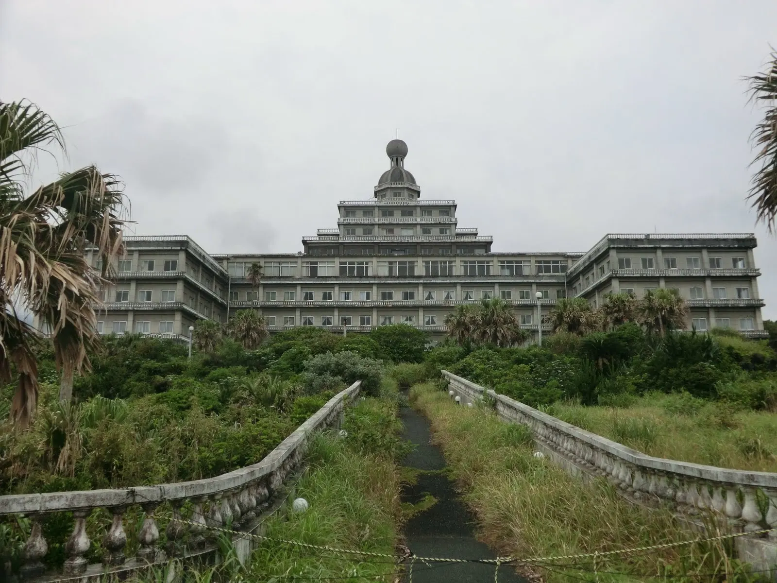 Façade du Hachijō Royal Hotel abandonné, envahi par la végétation sur l'île de Hachijōjima