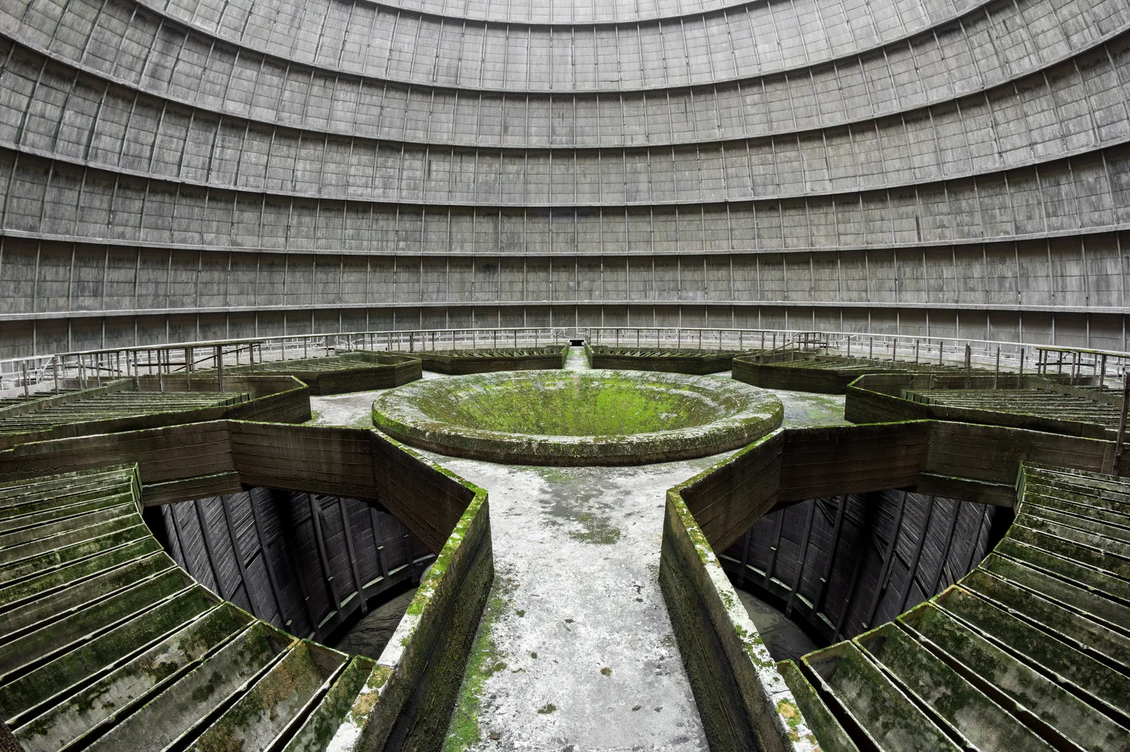 Intérieur de la tour de refroidissement abandonnée de Power Plant IM à Monceau-sur-Sambre, avec les rampes en étoile envahies de mousse