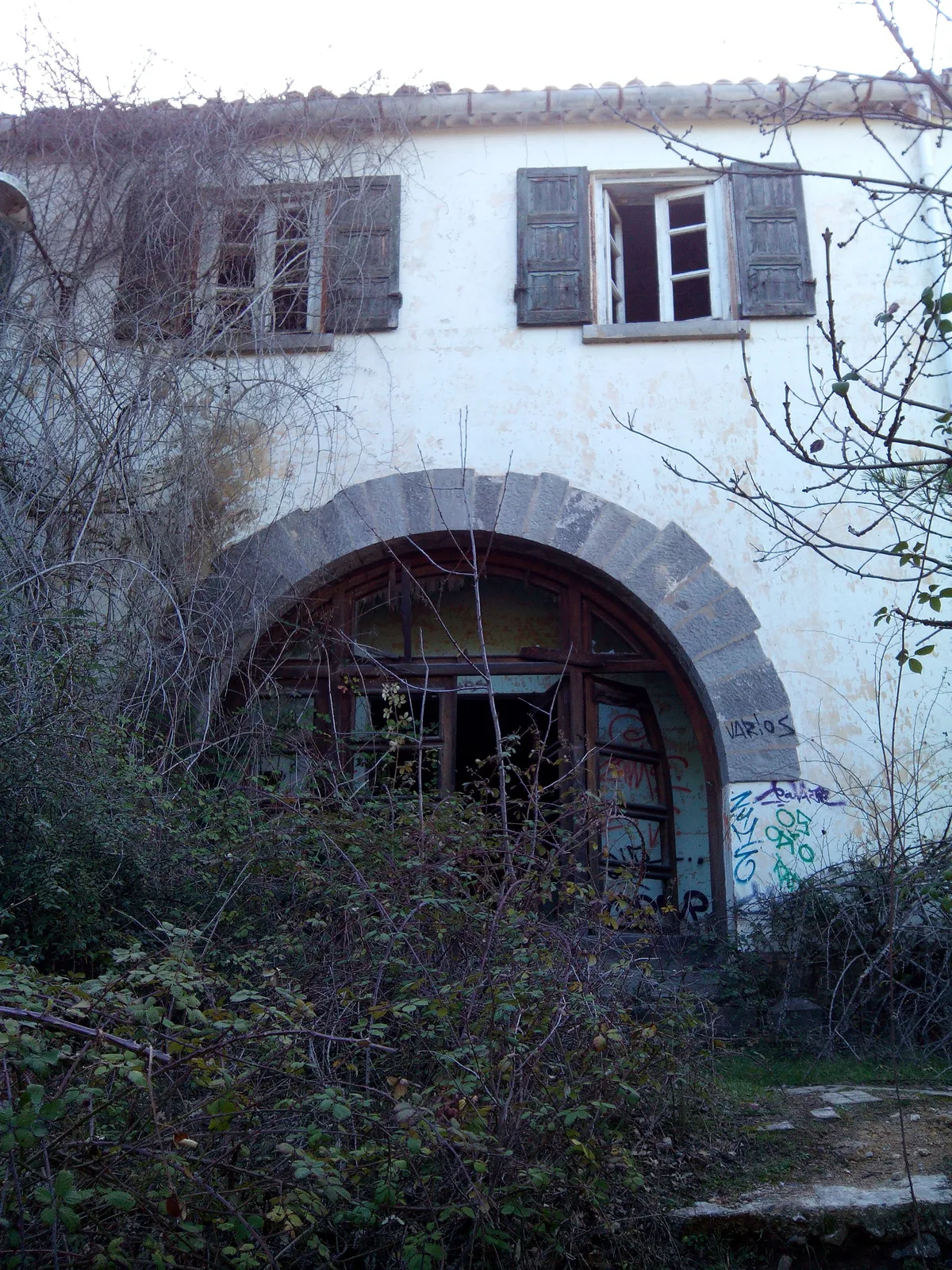 Entrada en ruinas del Sanatorio Antituberculoso de Agramonte, con arco de piedra y vegetación
