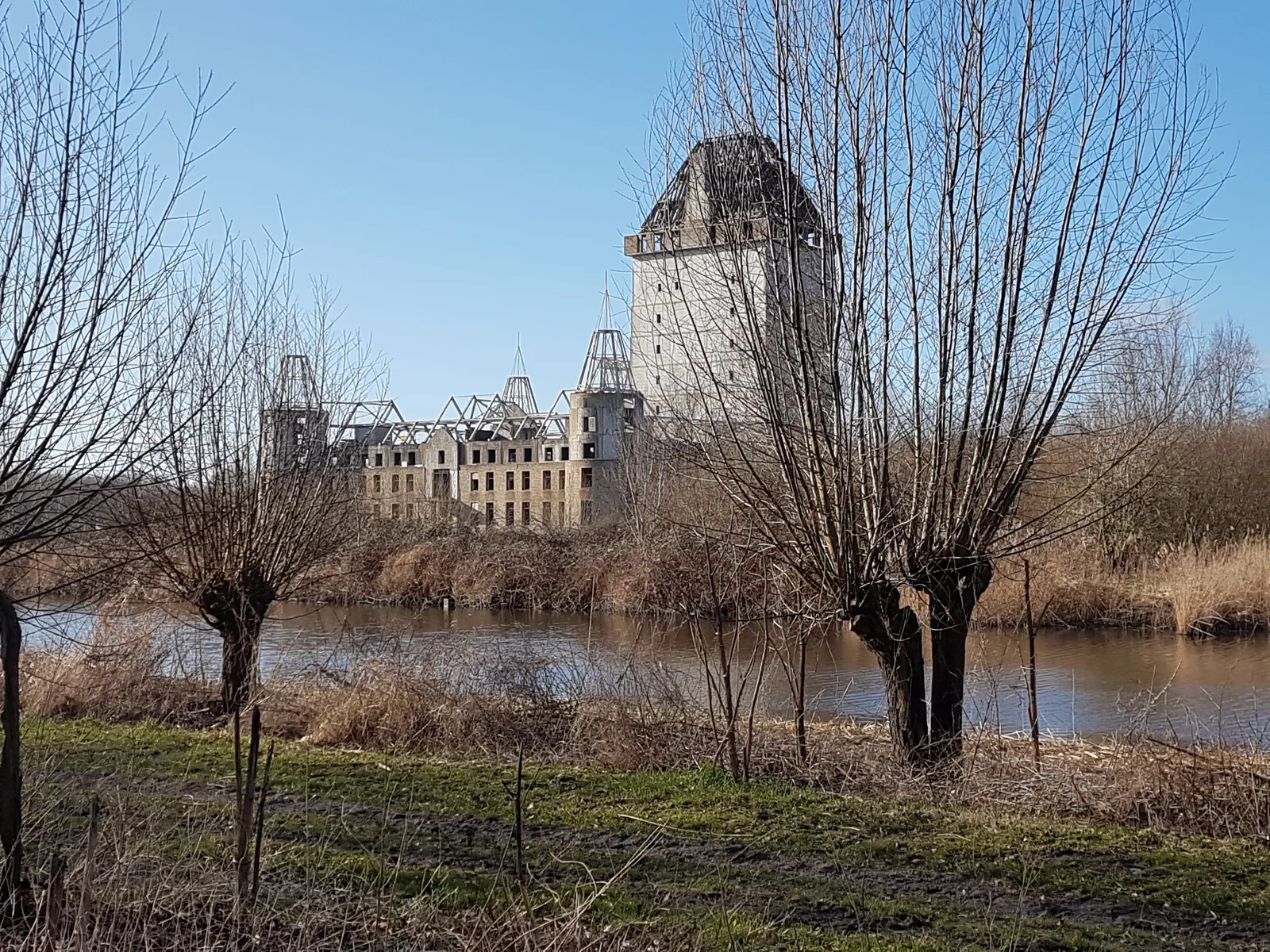 Het onafgebouwde betonnen Kasteel Almere dat als een ruïne boven het water uitsteekt