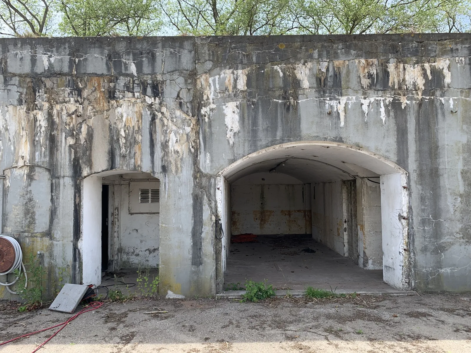 Het verweerde betonnen frontgebouw van het verlaten Fort bij Velsen met twee kazematopeningen, waaronder een bomvrije booggang, fort van de Stelling van Amsterdam