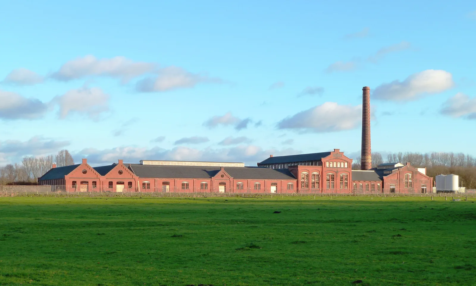 De oude strokartonfabriek De Toekomst II in Scheemda met rode baksteen en hoge schoorsteen