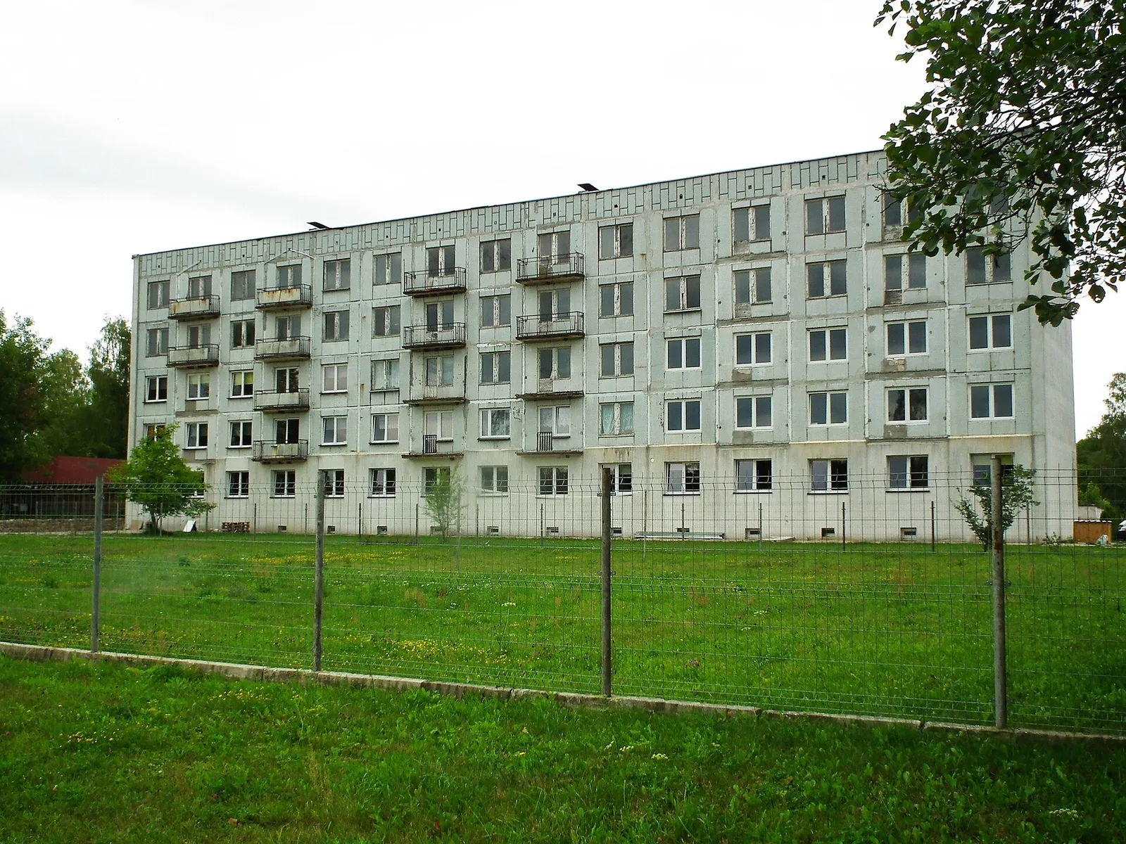 Opuszczone betonowe bloki mieszkalne w Klominie, dawnym miescie widmo, porosniete roslinnoscia