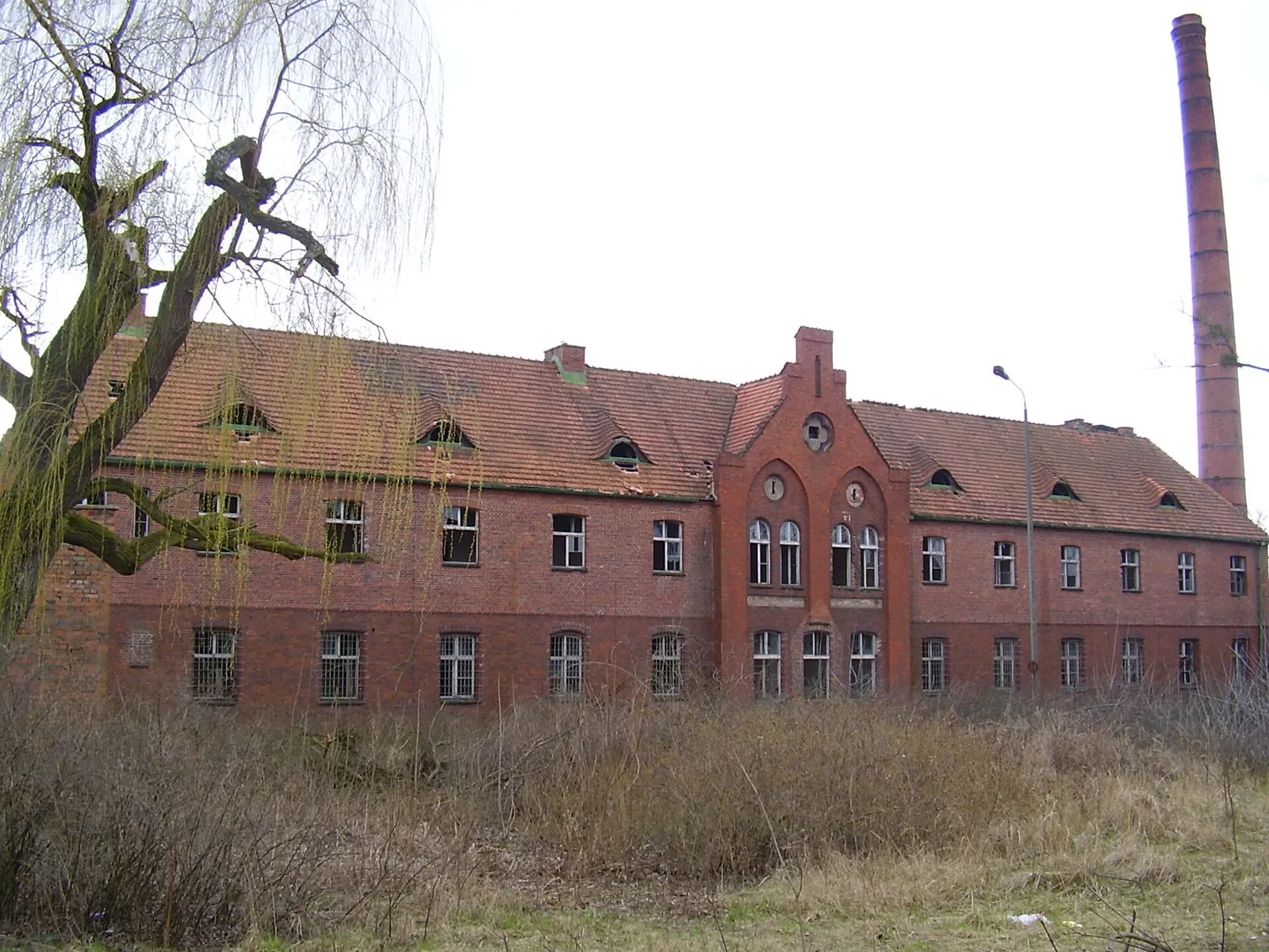 Opuszczony ceglany szpital psychiatryczny w Owinskach pod Poznaniem, z kominem i wybitymi oknami