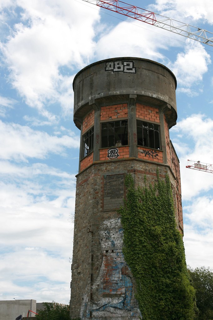 Le château d'eau abandonné de Baud-Chardonnet à Rennes, tour de brique et béton envahie de lierre, cernée par les grues du nouvel éco-quartier