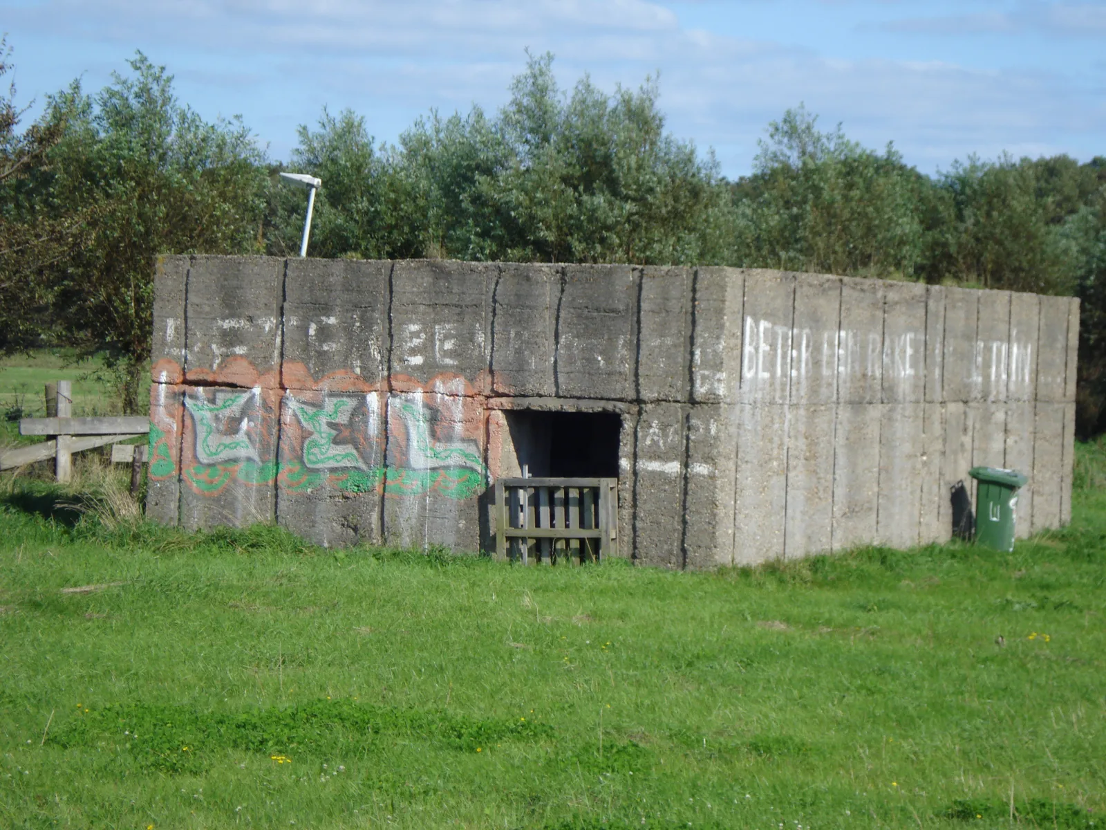 Met graffiti beschilderde verlaten betonnen bunker in een open veld bij het Staelduinse Bos in 's-Gravenzande
