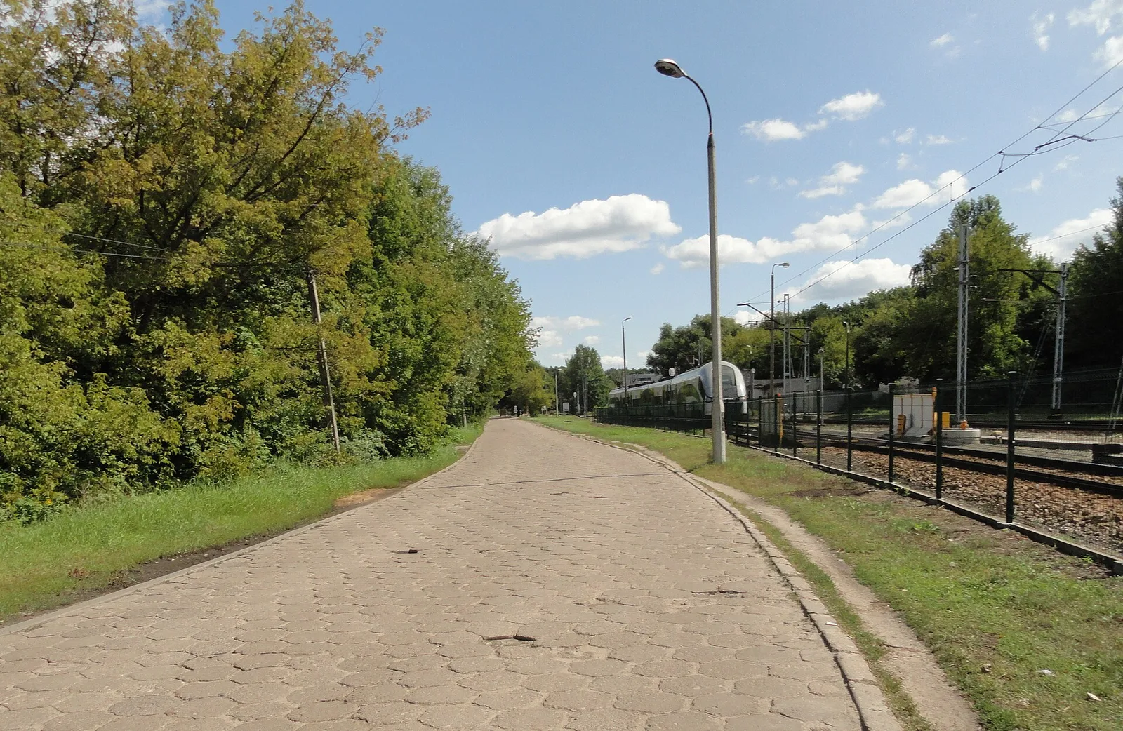 Opuszczona ulica osiedla Dudziarska w Warszawie wzdluz torow kolejowych